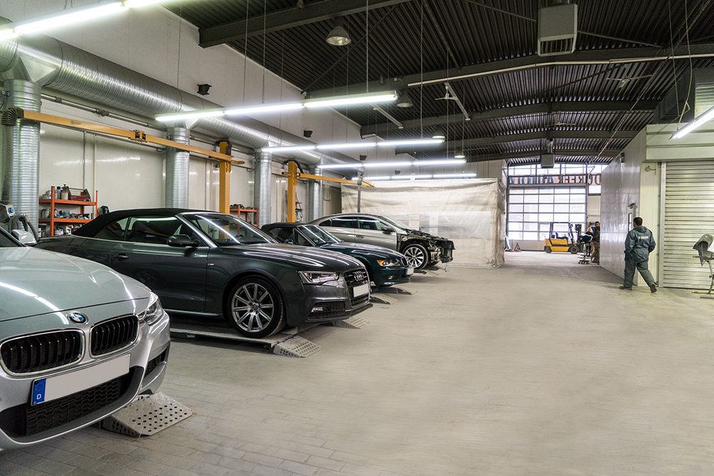 Moderne, helle Werkstatthalle mit Fahrzeugen